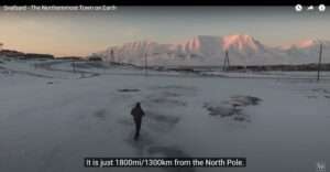 Screenshot showing a person standing alone in an icy landscape with snow covered hills
