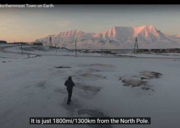 Screenshot showing a person standing alone in an icy landscape with snow covered hills
