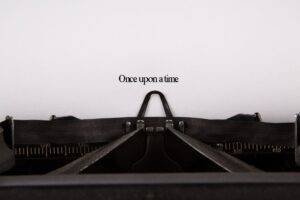 Photo of an old typewriter with a piece of paper saying Once upon a time