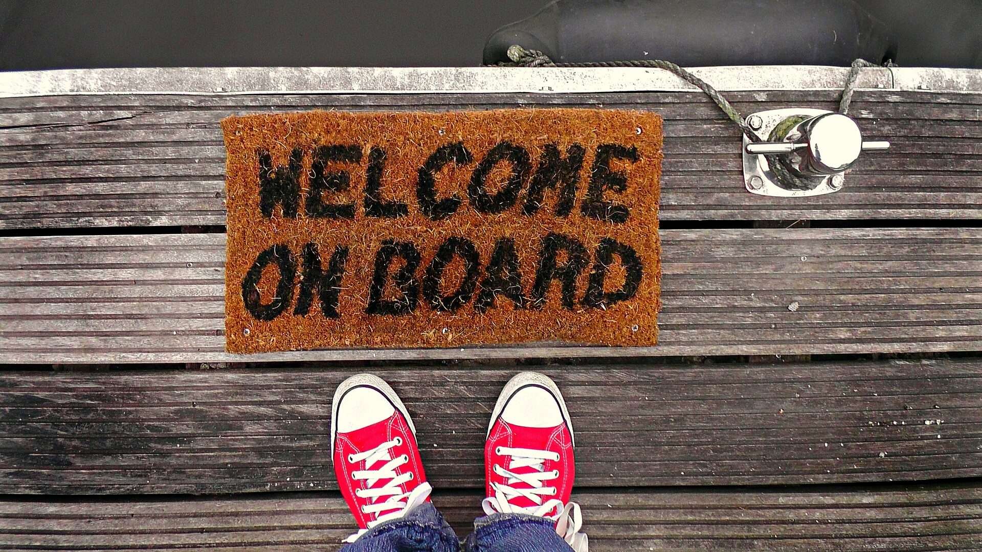 Person standing in front of "Welcome on Board" rug.